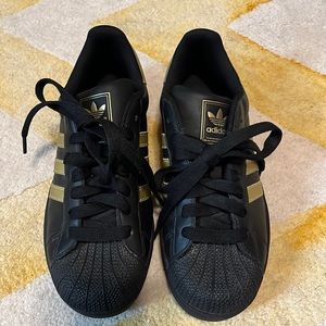 Like new. Discounted black and gold Adidas original Superstar shoes.